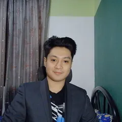 Christian T. Macion, dark blazer over graphic tee, three-quarter view, neutral background. Photographed February 2026.